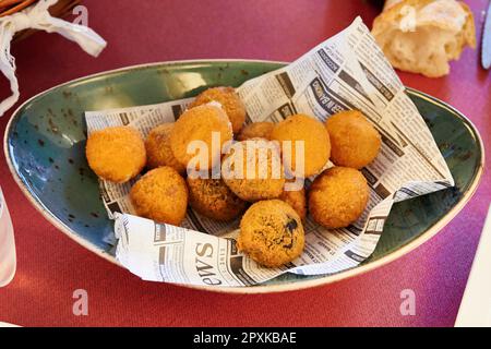 Une assiette de croquettes dorées et croustillantes de différentes saveurs, à l'intérieur doux et crémeux. Banque D'Images