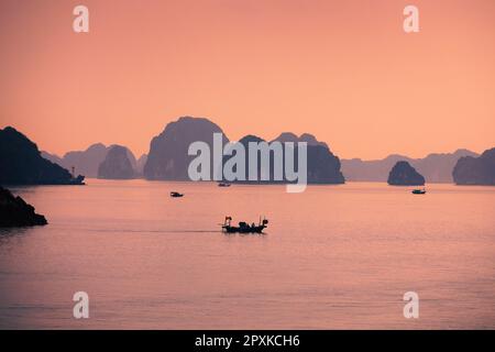Petits bateaux au milieu des formations karstiques en mer. Îles dans la célèbre baie de Ha long au Vietnam. Banque D'Images