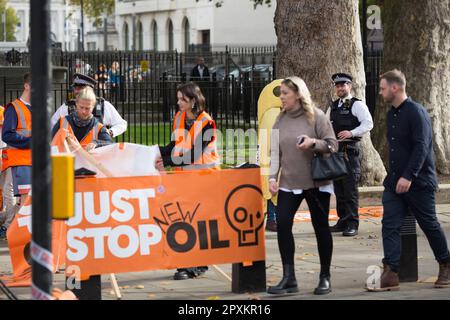 Les policiers discutent avec les activistes Just Stop Oil à Westminster, dans le centre de Londres. Banque D'Images