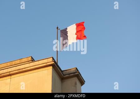 Un drapeau français vole dans le vent au coucher du soleil Banque D'Images