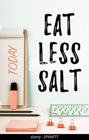 Signe écrit à la main manger moins de sel, mot pour réduire la consommation de sodium sur les aliments et les boissons Banque D'Images