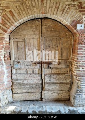 Cette image présente une porte en bois arquée avec des panneaux complexes Banque D'Images