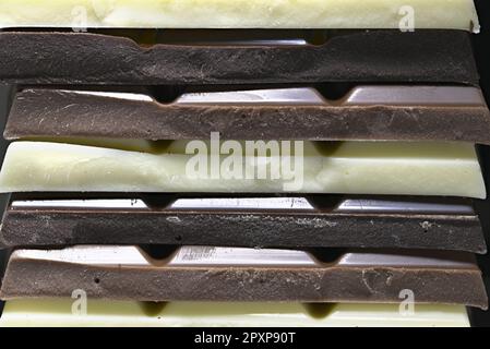 Chocolat noir, lait et blanc dans une pile Banque D'Images