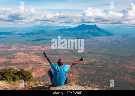 Vue arrière d'un randonneur faisant une pose de yoga sur le fond du mont Longido en Tanzanie Banque D'Images