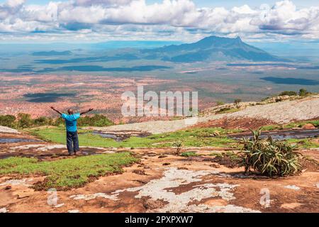 Vue arrière d'un randonneur faisant une pose de yoga sur le fond du mont Longido en Tanzanie Banque D'Images