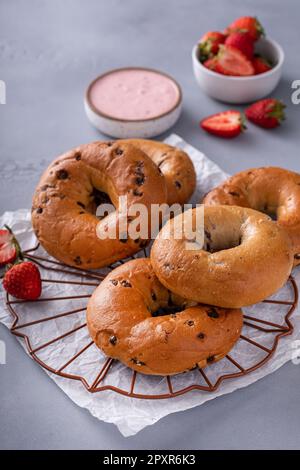 Variété de bagels servis avec des chés de crème à la fraise et des fraises fraîches Banque D'Images