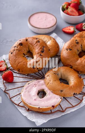 Variété de bagels servis avec des chés de crème à la fraise et des fraises fraîches Banque D'Images