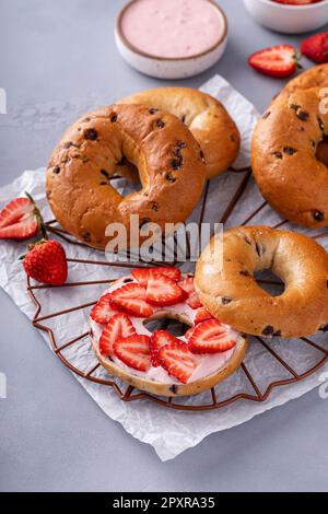 Variété de bagels servis avec des chés de crème à la fraise et des fraises fraîches Banque D'Images