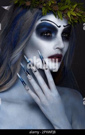 Portrait d'une horrible peur Corpse Bride en couronne, avec les fleurs mortes, Halloween maquillage et manucure long.Design d'ongles.Photo prise en studio Banque D'Images