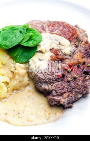 steak de bœuf avec sauce, purée de pommes de terre et feuilles d'épinards Banque D'Images