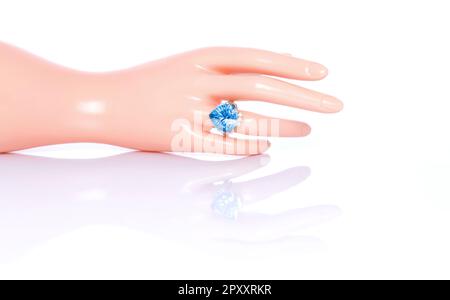 Coupe concave bleu suisse Topaz et bague diamant sur main femelle en plastique mannequin. Collection d'accessoires en pierres précieuses naturelles. Prise de vue en studio Banque D'Images