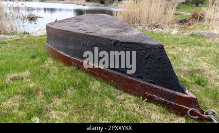 Les bateaux sont rentournés et se trouvent sur l'herbe à côté du lac. Banque D'Images