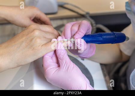 Manucure avec lime ou brosse pour ongles. Femme beau soin des ongles processus. Banque D'Images