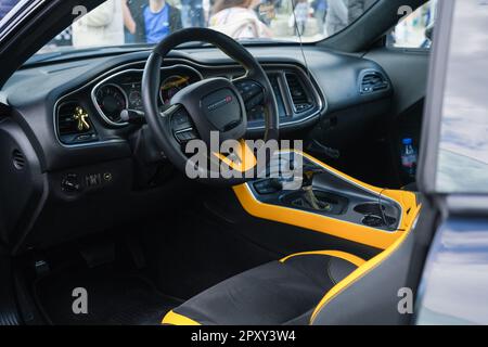 Gros plan d'une voiture de course Dodge jaune et noire du point de vue de l'intérieur, présentant le volant, le tableau de bord et le coin salon Banque D'Images