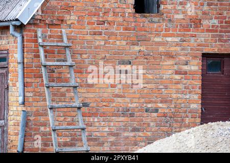 Un mur de briques avec une échelle contre lui. Banque D'Images