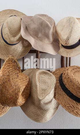 Porte-vêtements encombré de chapeaux en fibres végétales. Style campagnard Banque D'Images