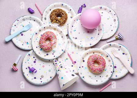 Assiettes jetables en papier avec beignets, ballons, chapeau de fête et  bougies sur fond de bois clair Photo Stock - Alamy