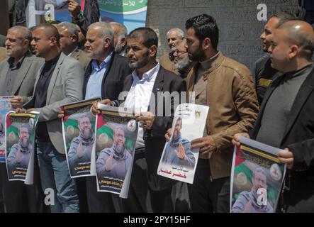 Les manifestants tiennent des affiches de Khader Adnan, un militant palestinien du Jihad islamique qui a été en grève de la faim en prison pendant près de trois mois et qui a été plus tard annoncé comme mort, lors d'un rassemblement. Les Palestiniens se réunissent pour protester à la suite de l'annonce par le service pénitentiaire israélien de la mort du détenu affilié au Jihad islamique (Khader Adnan) qui a été « retrouvé tôt ce matin dans sa cellule inconsciente ». Adnan (45), a été le premier palestinien à mourir directement à la suite d'une grève de la faim, selon le Club des prisonniers palestiniens. Banque D'Images