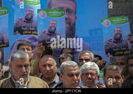 Les manifestants tiennent des affiches de Khader Adnan, un militant palestinien du Jihad islamique qui a été en grève de la faim en prison pendant près de trois mois et qui a été plus tard annoncé comme mort, lors d'un rassemblement. Les Palestiniens se réunissent pour protester à la suite de l'annonce par le service pénitentiaire israélien de la mort du détenu affilié au Jihad islamique (Khader Adnan) qui a été « retrouvé tôt ce matin dans sa cellule inconsciente ». Adnan (45), a été le premier palestinien à mourir directement à la suite d'une grève de la faim, selon le Club des prisonniers palestiniens. (Photo de Mahmoud Issa/SOPA Images/Sipa USA) Banque D'Images