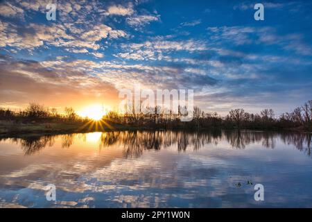 Une belle vue sur le lac étincelant sous le coucher du soleil dans la campagne Banque D'Images