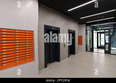 Boîtes aux lettres orange à l'intérieur du groupe d'entrée d'une tour résidentielle, Russie Banque D'Images