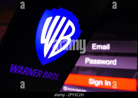 Dans cette illustration, la Warner Bros. Le logo divertissement s'affiche sur l'écran d'un smartphone, à côté d'un écran de connexion, avec e-mail, mot de passe et connexion. Banque D'Images