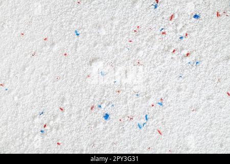 Titre poudre de lavage avec granules bleus et rouges gros plan, vue de dessus. Banque D'Images