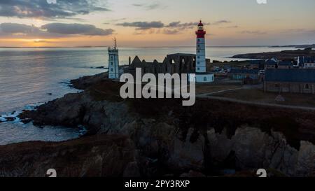 Vue aérienne du phare de la Pointe Saint Mathieu face au coucher de soleil sur l'océan Atlantique à l'extrémité ouest de la France près de Brest en Bretagne, Banque D'Images