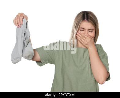 La jeune femme sent mal l'odeur des chaussettes sales isolées sur blanc Banque D'Images