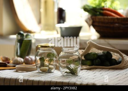 Vider les pots en verre et les ingrédients préparés pour être mis en conserve sur la table Banque D'Images