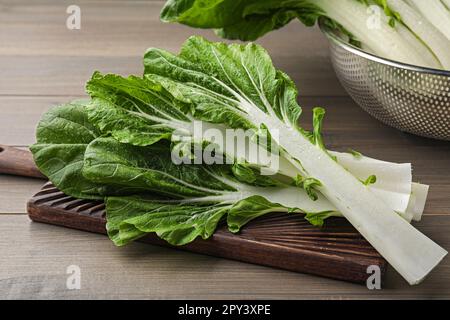 Feuilles de chou blanc vert frais avec gouttes d'eau sur une table en bois Banque D'Images