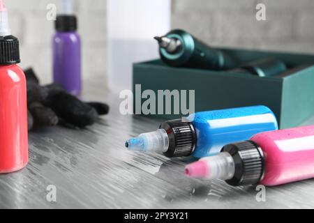 Bouteilles d'encres tattoo colorées sur la table en salon Banque D'Images