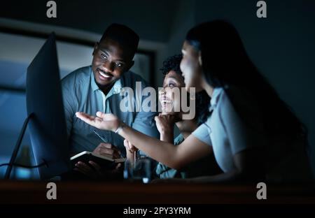 Le dévouement est toujours bien récompensé. un groupe de jeunes hommes d'affaires utilisant un ordinateur ensemble pendant une nuit de travail. Banque D'Images