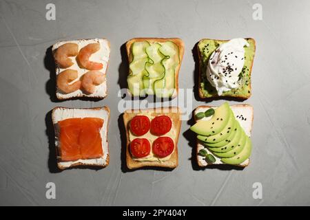 Différents toasts délicieux sur table gris clair, plat Banque D'Images