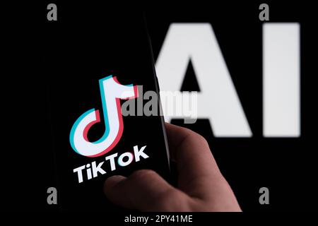 Logo TikTok visible sur le smartphone et lettres ai sur l'arrière-plan. Concept pour l'intelligence artificielle de TikTok. Stafford, Royaume-Uni, 2 mai 2023 Banque D'Images