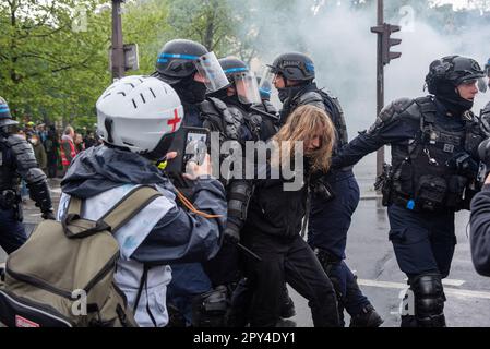 Paris, France. 01st mai 2023. La police enlève une femme arrêtée qui semble très mal pendant la manifestation de la fête du travail à Paris. Des centaines de milliers de personnes ont assisté à la manifestation de la fête du travail à Paris pour demander de mettre un terme à la très impopulaire réforme des retraites. La manifestation a dégénéré en très peu de temps. Les manifestants et la police se sont affrontés plusieurs fois au cours de la journée. Les manifestants ont fait irruption dans les boutiques et allumé tout ce qui était inflammable. La police a déployé des canons à eau et des gaz lacrymogènes pour arrêter l'émeute. Crédit : SOPA Images Limited/Alamy Live News Banque D'Images