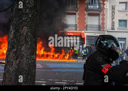 La police et quelques pompiers sont vus sur les lieux où un bâtiment brûle lors de la manifestation de la fête du travail à Paris. Des centaines de milliers de personnes ont assisté à la manifestation de la fête du travail à Paris pour demander de mettre un terme à la très impopulaire réforme des retraites. La manifestation a dégénéré en très peu de temps. Les manifestants et la police se sont affrontés plusieurs fois au cours de la journée. Les manifestants ont fait irruption dans les boutiques et allumé tout ce qui était inflammable. La police a déployé des canons à eau et des gaz lacrymogènes pour arrêter l'émeute. (Photo de Krisztian Elek/SOPA Images/Sipa USA) Banque D'Images