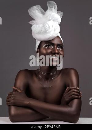 Parfois, les accessoires les plus simples parlent le plus fort. Photo en studio d'une jeune femme attrayante posant dans une tenue africaine traditionnelle contre un gris Banque D'Images