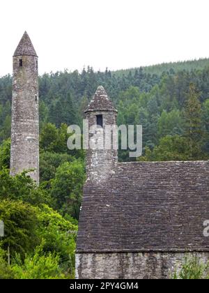 L'architecture ancienne de la cuisine de Saint Kevin et de la tour ronde de la ville monastique de Glendalough, dans le parc national des montagnes de Wicklow, en Irlande. Banque D'Images