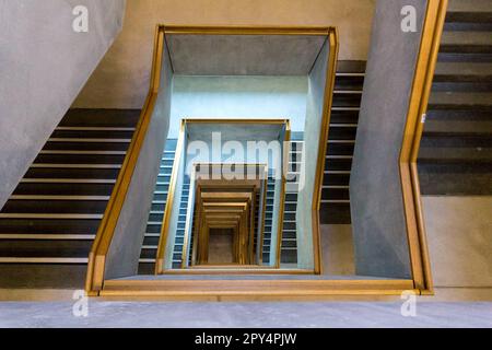 Escalier contemporain en béton avec main courante en bois, vue depuis le dernier étage Banque D'Images