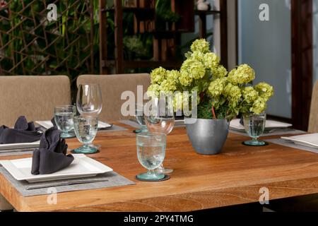 Grande table à manger en bois avec belle fleur au centre sur le balcon Banque D'Images