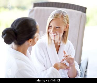 Heureux, parlant et amis avec de la crème dans un spa pour les mains, le traitement et le bien-être de la peau. Souriez, prenez soin de la peau et parlez aux femmes tout en appliquant de la lotion pour Banque D'Images