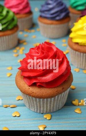 Délicieux cupcake à la crème rouge et aux arrosettes en forme de coeur sur une table en bois bleu clair Banque D'Images