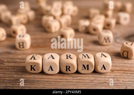 Mot Karma fait de cubes avec des lettres sur une table en bois Banque D'Images