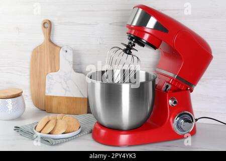 Batteur rouge moderne et biscuits sur table en marbre blanc Banque D'Images