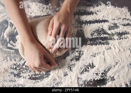 Femme pétriant de la pâte à la table, vue rapprochée Banque D'Images