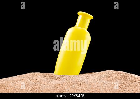 Bouteille jaune Mockup pour produits cosmétiques crème solaire, crème solaire, shampooing sur plage de sable isolé fond noir. Concept créatif de soin de la peau. Vacances Banque D'Images