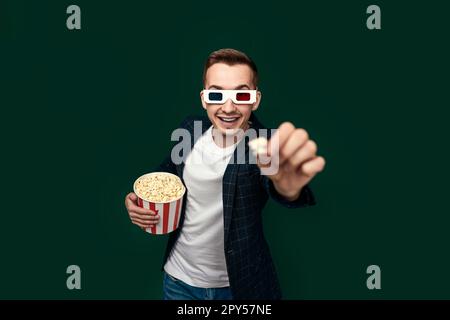 Jeune homme caucasien dans 3D verres mangeant du pop-corn Banque D'Images