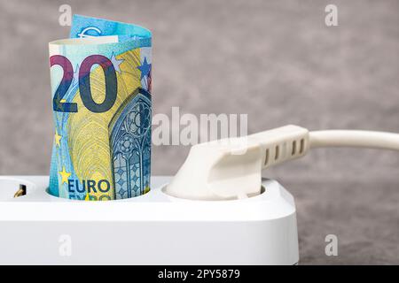 20 billets de banque d'euros branchés sur une barre d'alimentation blanche Banque D'Images