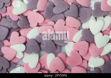 Sucre plein de couleur parsemé de points une forme du coeur, un ornement pour une tarte et des produits de boulangerie, beaucoup d'éclaboussures comme un fond. gros plan Banque D'Images